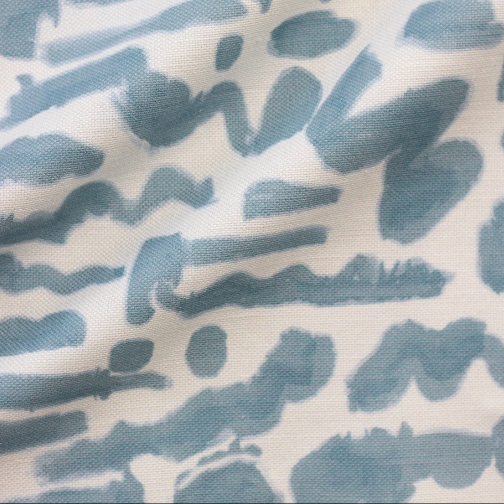 A fabric with a blue and white doodle pattern.