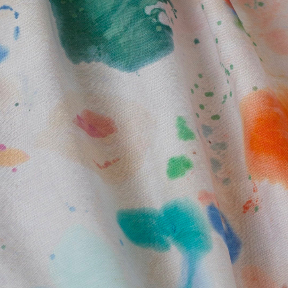 A fabric with a colorful paint splatter design.