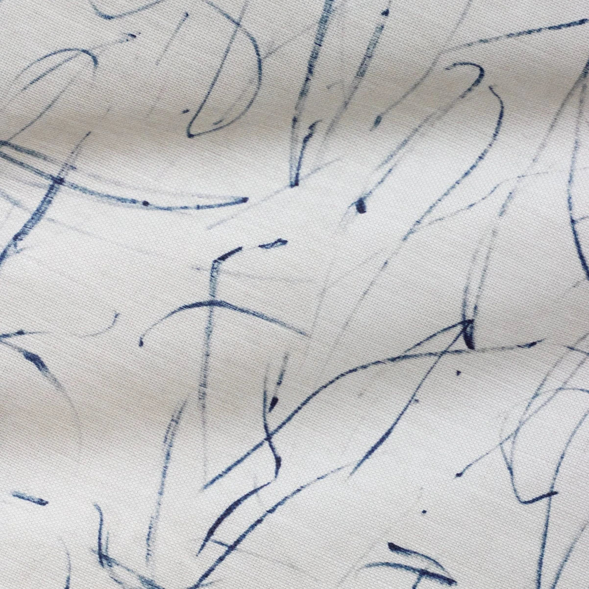 Abstract blue ink strokes on a white fabric background