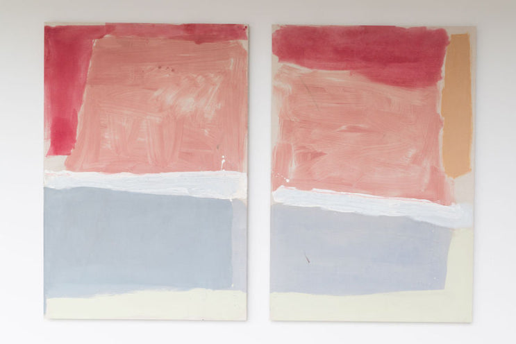 Two abstract paintings with pink and gray colors on a white wall.