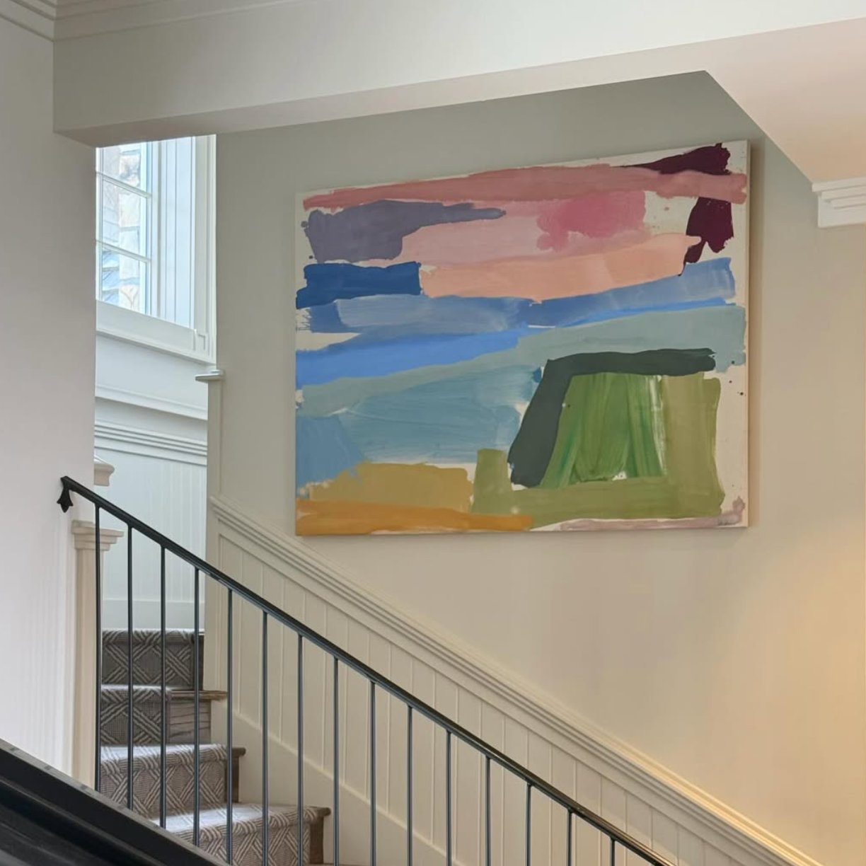 Abstract painting on a wall above a staircase