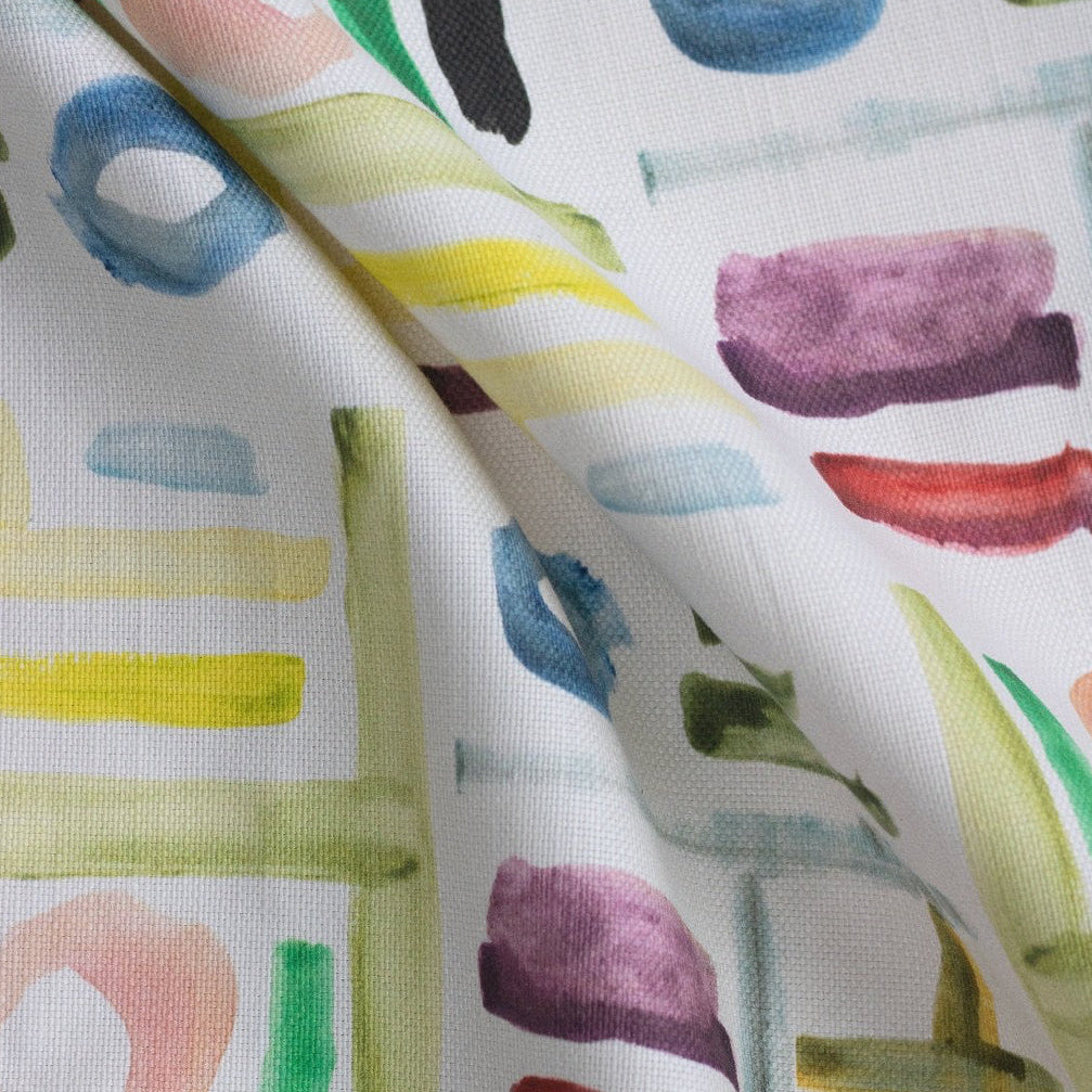 A fabric with a hand-painted design featuring abstract geometric shapes in various colors.