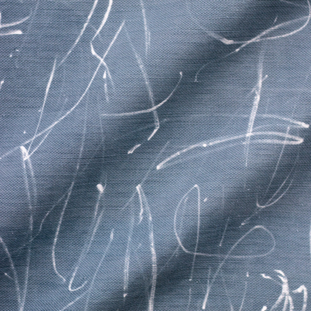 A fabric with a blue color and a abstract white line pattern.