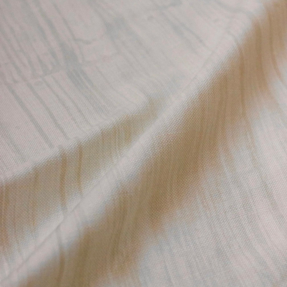 Close-up of a fabric with a subtle pattern on a light background