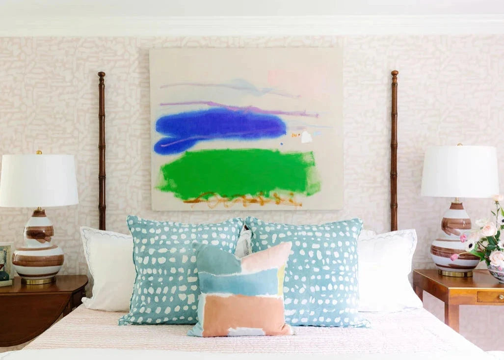 Bedroom with a bed featuring decorative pillows and a colorful abstract painting on the wall.